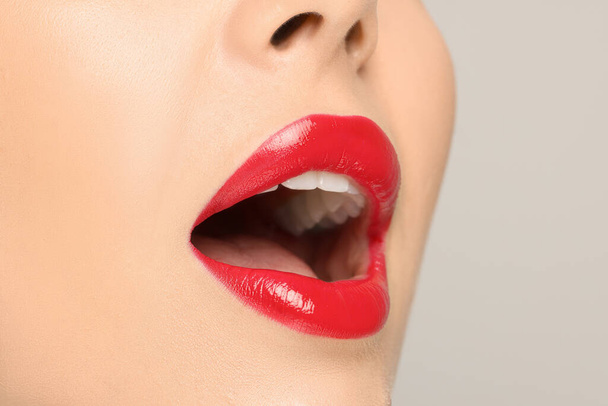 Woman with red lipstick on light background, closeup - Foto, imagen