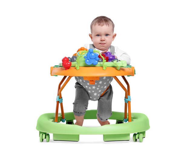 Cute little boy making first steps with baby walker on white background - Foto, immagini