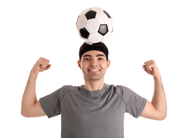 Sportlicher junger Mann mit Fußball auf weißem Hintergrund. Gleichgewichtskonzept - Foto, Bild