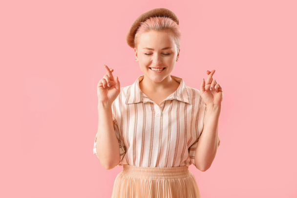 fiatal nő keresztbe ujjak rózsaszín háttér - Fotó, kép