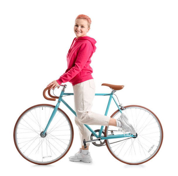 Mujer joven con bicicleta sobre fondo blanco - Foto, imagen