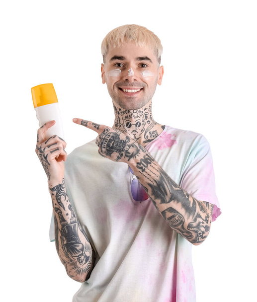 Tattooed man with sunscreen cream on white background - Foto, imagen
