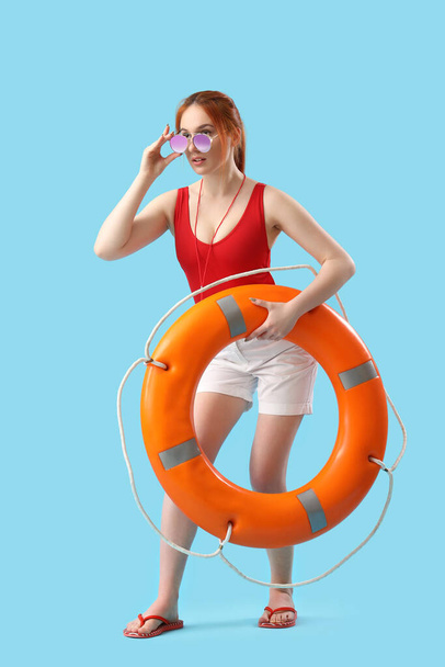 Rettungsschwimmerin mit Ringboje auf blauem Hintergrund - Foto, Bild