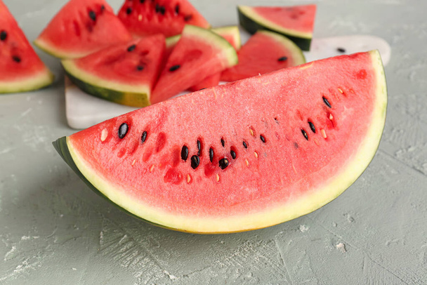 Board with pieces of fresh watermelon on grey table - Fotoğraf, Görsel