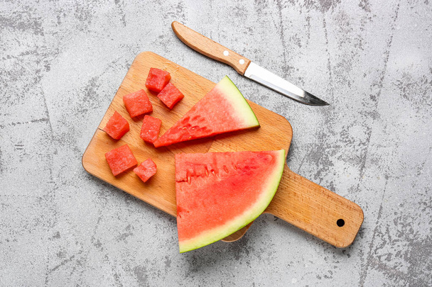 Board mit Stücken von frischer Wassermelone auf grauem Hintergrund - Foto, Bild
