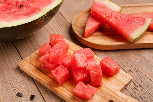 Desky s kousky sladkého melounu na dřevěném pozadí - Fotografie, Obrázek