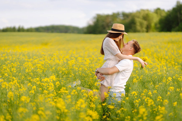 Young Couple in the blooming field. Nature, vacation, love, relax and lifestyle. Summer landscape.  - Foto, Imagem