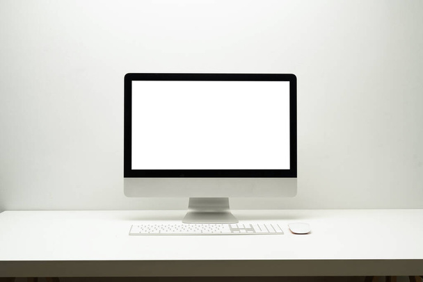 Vooraanzicht van bankscherm computer, draadloos toetsenbord en muis op witte tafel. Blanco scherm voor uw webpagina of reclame tekst. - Foto, afbeelding