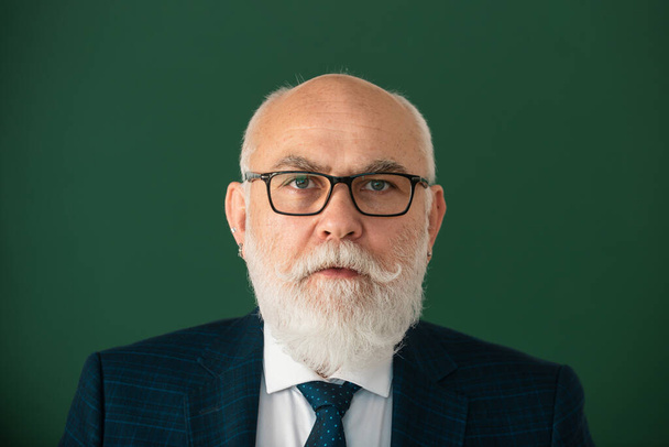 Een close-upportret van een oude mannelijke professor. Portret van een man met kopieerruimte. Succesvol gezicht van volwassen leraar met bril - Foto, afbeelding