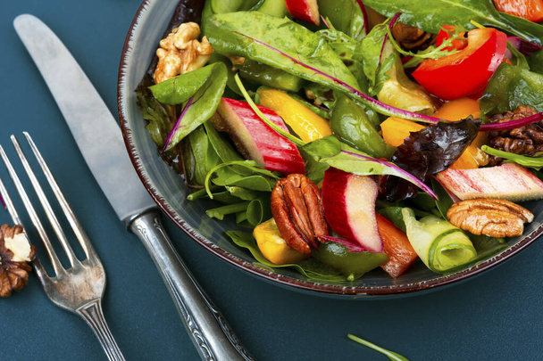 Leckere Salatschüssel mit Pfeffer, Rhabarber, Nüssen und Salat. - Foto, Bild