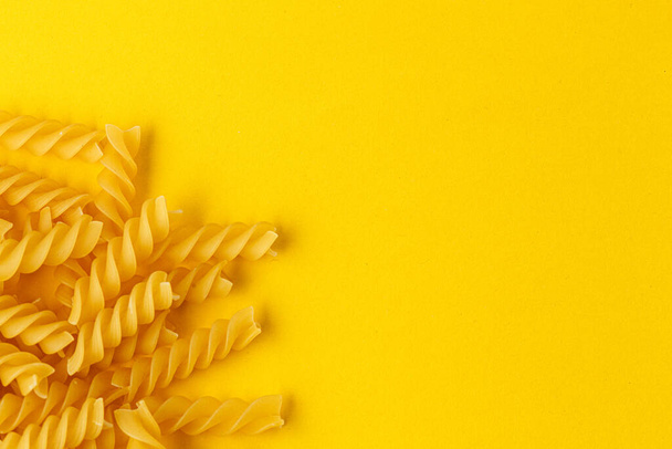 Different types and shapes of dry italian pasta on a yellow background close-up - 写真・画像