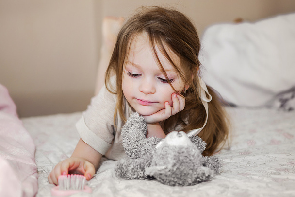 Μικρό κορίτσι στο κρεβάτι, παίζει - Φωτογραφία, εικόνα
