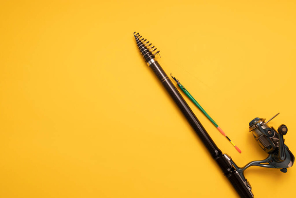 Design Fishing Spinning Rod, Reel on Yellow Background. Hobby, Leisure. Mockup, Copy Space for Text. Horizontal Plane. High quality photo - Photo, Image