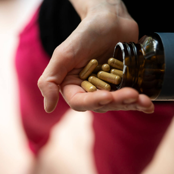 Detailní pohled na ženskou ruku plnou doplňků stravy pilulky vitamínů a základních živin. - Fotografie, Obrázek