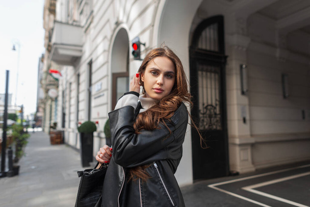 Módní městský Kavkazský krása žena s černou koženou bundou a taškou procházky ve městě - Fotografie, Obrázek