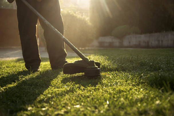Mowing the grass with a lawn mower. Garden work concept background. - Fotó, kép