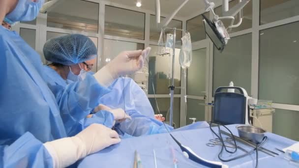 Medical personnel in special sterile clothing during surgery in the operating room. Professional treatment of diseases - Footage, Video