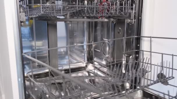 Empty dishwasher after work. A man in rubber gloves closes the dishwasher door. - Footage, Video