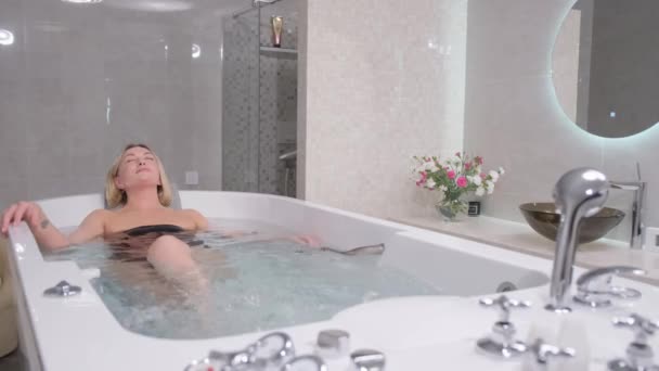 Eine schöne Frau unterzieht sich einer Hydromassage. Schöne Frau entspannt sich in der Badewanne bei einer Hydromassage-Therapie. - Filmmaterial, Video