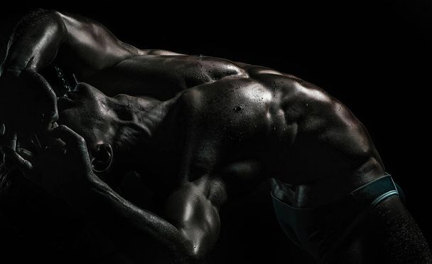 Sexy young handsome naked man on dark background. Seductive gay - Fotó, kép
