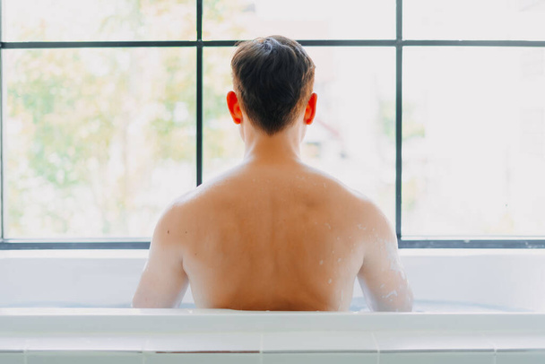 Back of asian man showering in the bathtub in the bathroom. - Fotografie, Obrázek