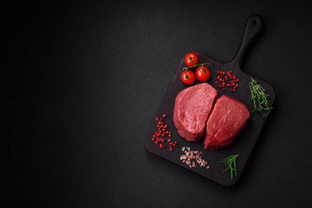 Raw beef eye steak round with salt, spices and herbs prepared for grilling on a textured background - Фото, зображення
