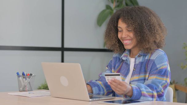 Mujer afroamericana emocionada por el éxito de las compras en línea en el ordenador portátil - Foto, Imagen