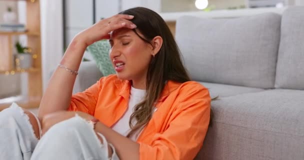 Woman, headache and pain in home with stress, dizzy mind and mental health crisis. Sick female with migraine, tension and anxiety in brain of burnout, medical problems and frustrated face in lounge. - Filmmaterial, Video