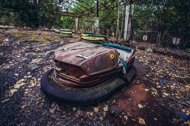 Κόκκινο συγκρουόμενο αυτοκίνητο στην εγκαταλελειμμένη πόλη Pripyat στο Τσέρνομπιλ Αποκλειστική Ζώνη, Ουκρανία - Φωτογραφία, εικόνα