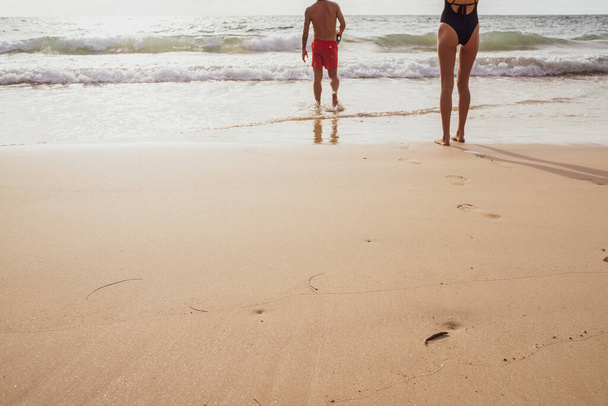 Couple walking on sea beach into the sea summer beach - Φωτογραφία, εικόνα
