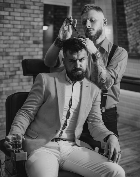 Man visiting hairstylist in barber shop. Professional hairstylist in barbershop interior. Barber - Shaves and Trims. Hair style and hair stylist - Photo, image