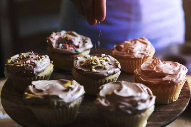 Käsi lisäämällä strösseleitä suklaa cupcake ruoka valokuvaus resepti idea
 - Valokuva, kuva