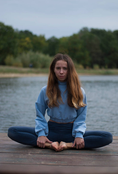 View on a girl in Lotus Pose near lake in rainy weather - Fotografie, Obrázek