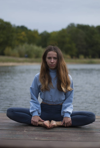 Vue de la jeune fille fait du yoga près du lac - Photo, image