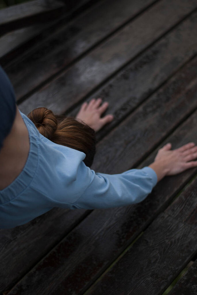 Pohled na dívku s atletickým tělem v modrém tělocvičně dělá jógu cvičení v oblačném deštivém počasí v par - Fotografie, Obrázek