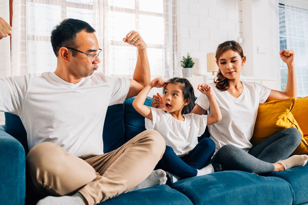 Vader moeder en dochter doen oefening in de woonkamer thuis, Gezond en fit familie doen thuis stretching yoga oefening samen, Familie spelen samen thuis, Familie met een gezonde levensstijl - Foto, afbeelding