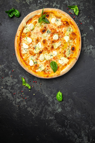 four cheese pizza, homemade italian pizza. Pizza on rustic black background. Traditional italian cuisine. place for text, top view. - Photo, Image