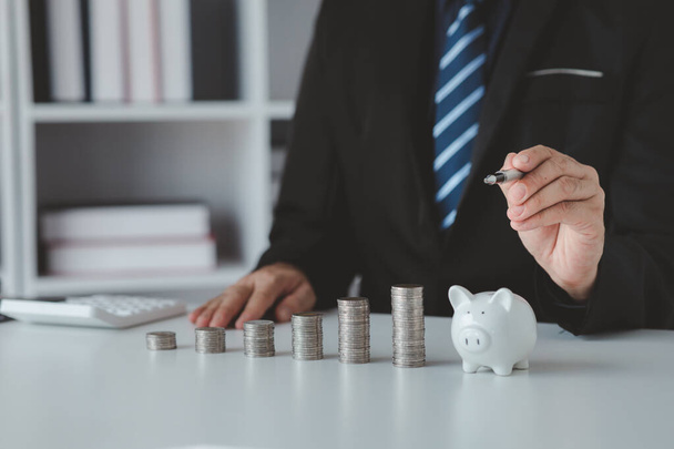 Person with pile of coins and piggy bank, money saving concept for future use and financial stability, salary management, personal finance, investment savings. - Foto, Imagen