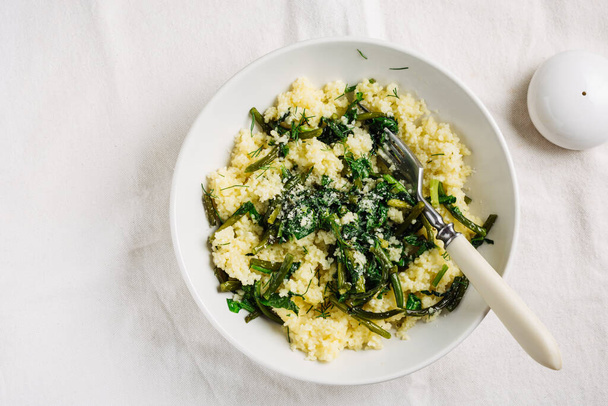 Couscous with garlic arrows and spinach, top view. Vegan cuisine. - Foto, immagini