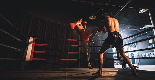 Aziatische en Kaukasische Muay Thai bokser ontketenen knieaanval in felle bokstraining, leveren kniestaking aan sparring trainer, presenteren Muay Thai bokstechniek en vaardigheid. Aansporing - Foto, afbeelding