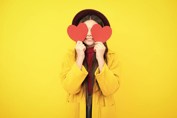 Happy teenager portrait. Lovely child girl 12, 13, 14 years old with shape heart love holiday and valentine symbol. Valentine or birthday day. Smiling girl - 写真・画像