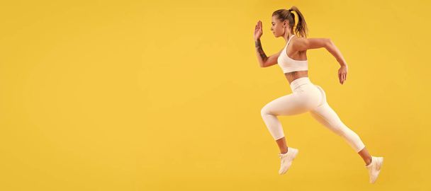 fitness woman runner running on yellow background. Woman jumping running banner with mock up copyspace - Foto, Imagem