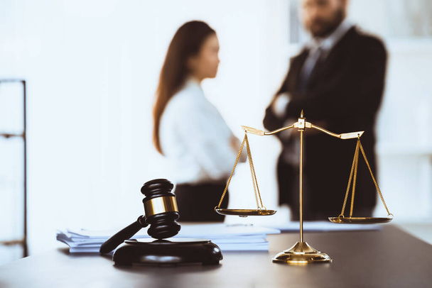 Balanced scale of justice and gavel hammer in focus on blurred background of lawyer colleagues discuss and plan for lawsuit in law firm office, as legal representatives. Equilibrium - Foto, immagini