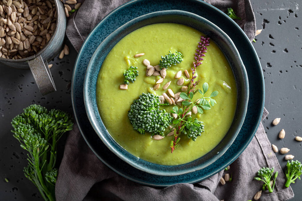 Healthy broccoli soup served in blue bowl. Vegan soup made of vegetables. - Фото, изображение