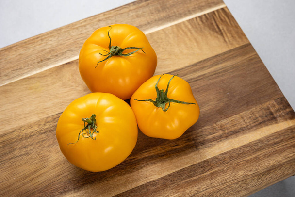 Yellow tomatoes in the background. Close up - Фото, зображення