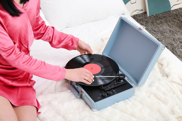 Young woman with record player in bedroom, closeup - Photo, image