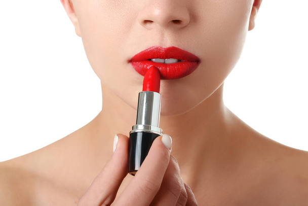 Femme appliquant rouge à lèvres rouge sur fond blanc, gros plan - Photo, image