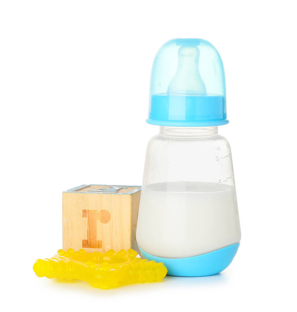 Botella de leche para bebé con juguetes aislados sobre fondo blanco - Foto, imagen
