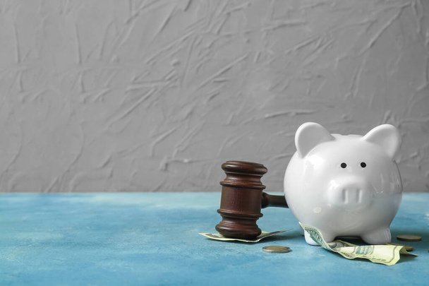 Piggy bank with judge gavel and money on grunge blue background. Concept of bankruptcy - 写真・画像