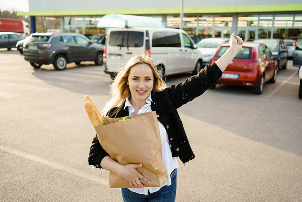 Women enjoying the outdoors, holding paper bags filled with fresh and healthy items, their smiles reflecting the happiness of their grocery store experience. - Photo, Image